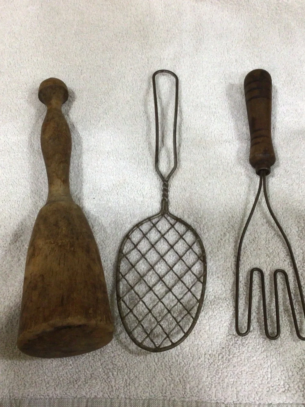 Primitive kitchen set for display. Wooden pestle, potato masher and skimmer.